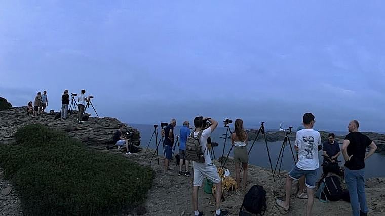 Algunos de los participantes en la quedada de astrofotografía frente al faro de Favarich (Menorca), al fondo de la imagen